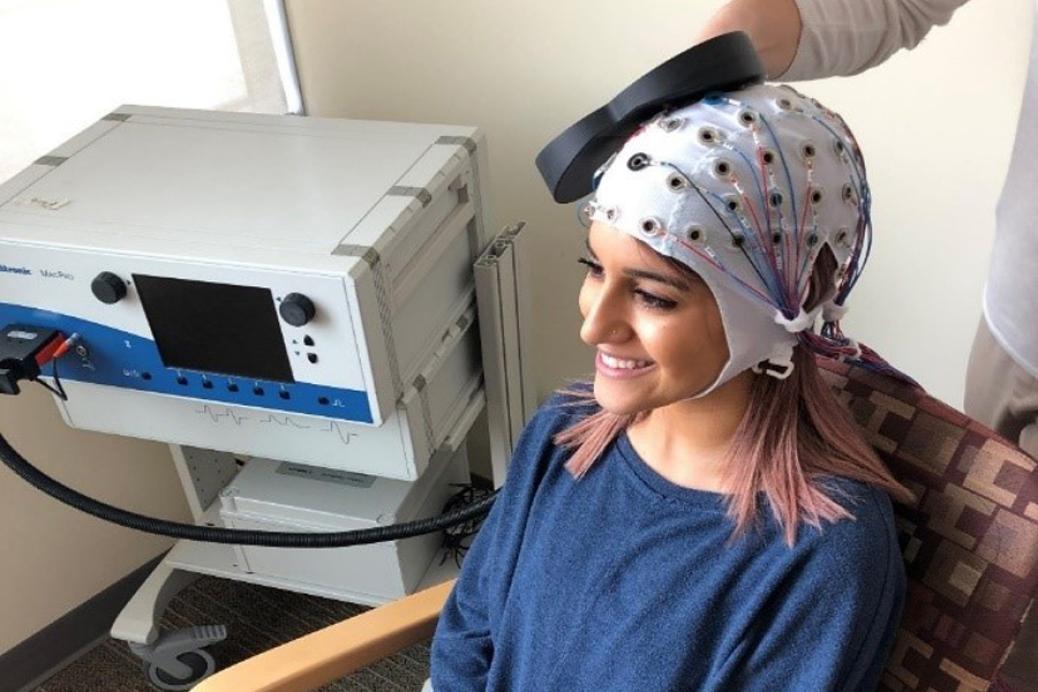 Une femme portant une casquette pour la stimulation magnétique transcrânienne répétitive (rTMS)