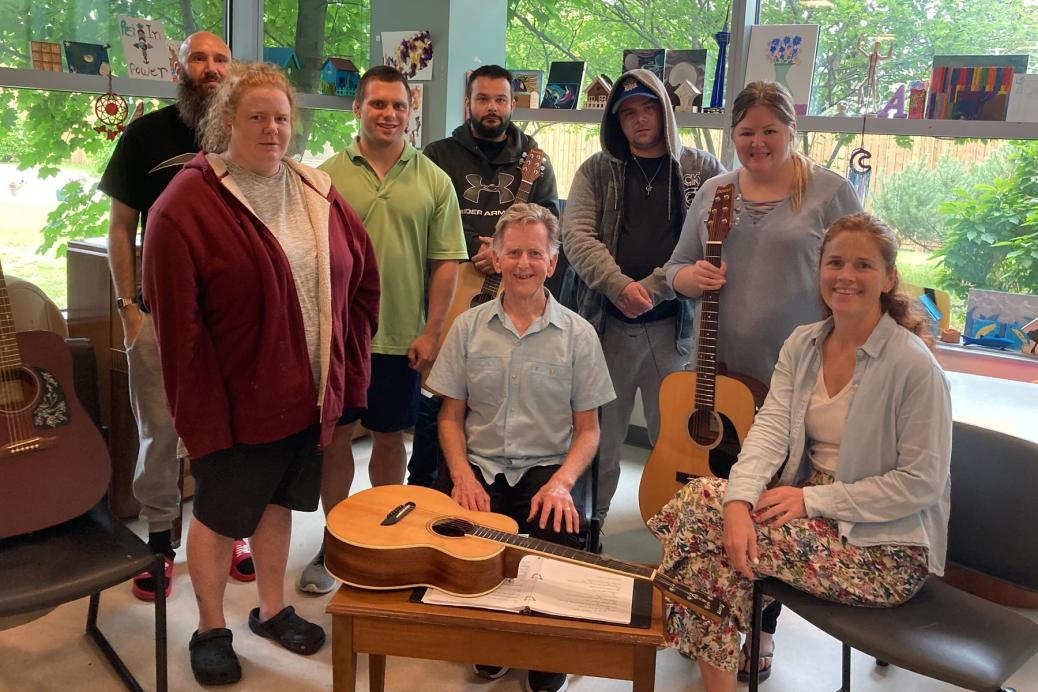 Michael Fahey, musicien d’Ottawa (au centre), et Ashleigh McGuinty, récréothérapeute (assise à droite), avec certains membres du groupe de guitare du Royal.