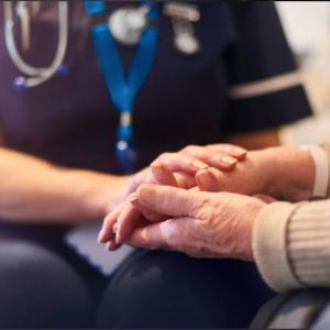 Caregiver holding hands with patient