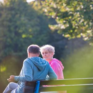 Man and woman sitting on a bench outside