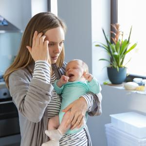 Une mère épuisée tenant son enfant dans ses bras