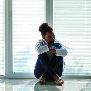 Femme vidée de son énergie assise par terre, épuisée